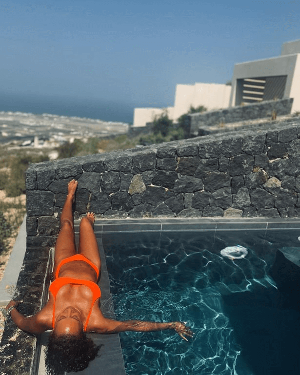 A show-stopping holiday snap from Spice Girl icon Mel B shows her lounging by a pool in a string bikini enjoying the sun.