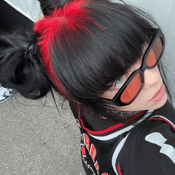 Another selfie shows Billie's red roots, but this time she wore a basketball jersey and black sunglasses with red lenses.