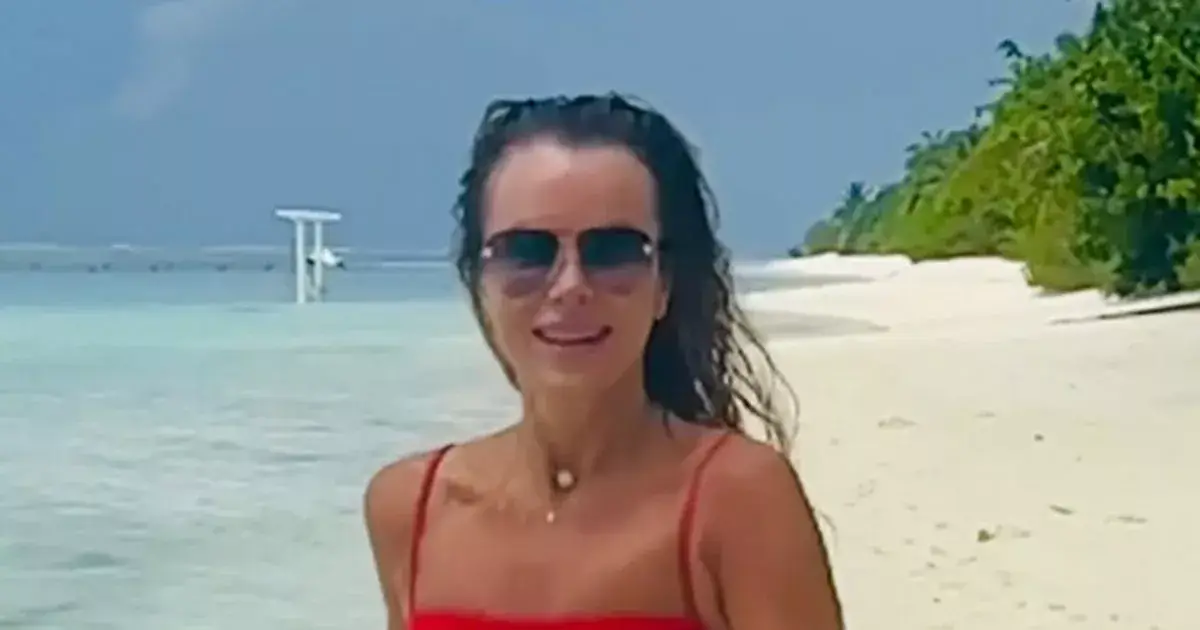 In a tiny red bikini, Amanda Holden showed off her toned physique while running across the beach