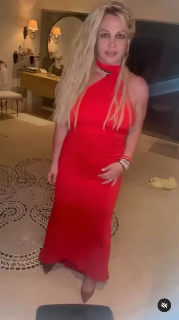 Britney Spears has left fans concerned after she poses in a slinky red halter-neck dress and struts around