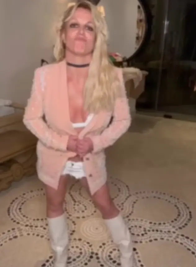 Taking to the tiles in her hotel room bathroom in white go-go boots, the singer showed off her moves in a tiny white bikini top styled with white cut-off shorts and a pink jacket.
