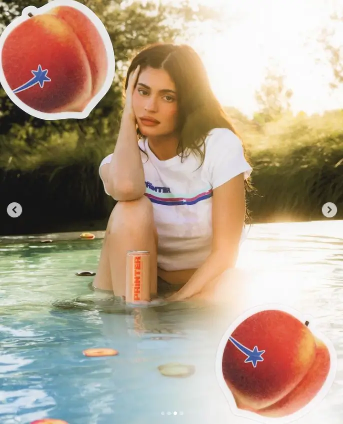 In another photo, she is seen sitting beside a shallow swimming pool while holding a can of her beverage. She also has her eyes closed as water shoots toward her.