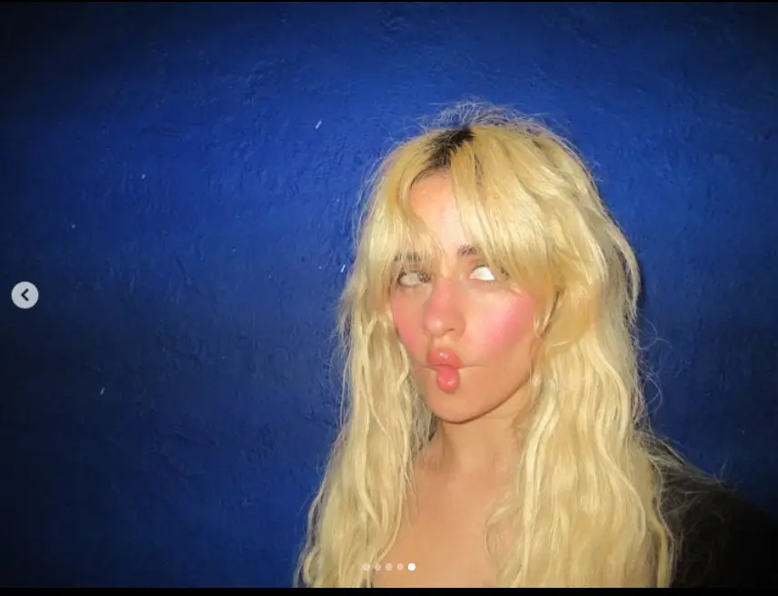 Another shot shows Camila puckering her lips against a blue wall.