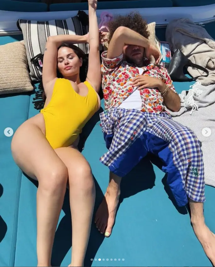 a stunning photograph of Gomez soaking up the sun beside her boyfriend on the deck of a yacht shows her in a bright yellow one-piece swimsuit with her hair left down.