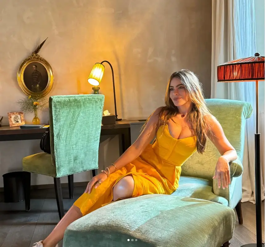 On a chaise lounge in her villa, Sofia Vergara looked casual in a yellow sundress with a plunging V-neck, sneakers and straight brunette hair.