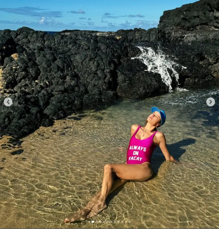 Putting on a cheeky display for Instagram on Friday, Alessandra Ambrosio relaxed on a Hawaiian beach, wearing a magenta swimsuit and a blue baseball cap.