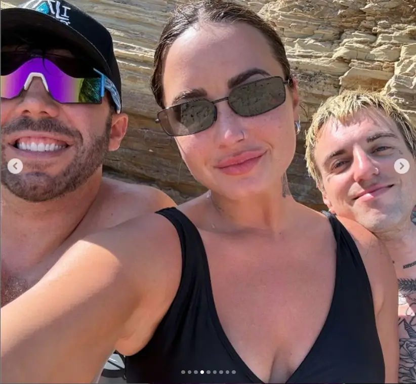 Demi Lovato snapped vacation snaps with Jutes and a friend, showing off her curvy figure in a plunging black swimsuit and smiling in shades while showing her cleavage. 