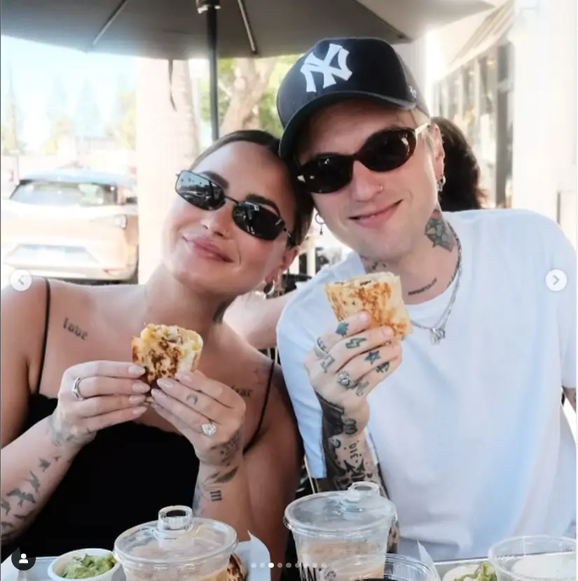 The third photo shows Demi wearing a black strappy top for some outdoor dining with Jutes and flashing her many tattoos, as well as showing off her healthy appetite.