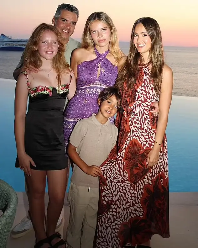 Jessica Alba looked radiant as she posed with Cash Warren and their three children. She wore a flowing red floral dress that made her look like a goddess.