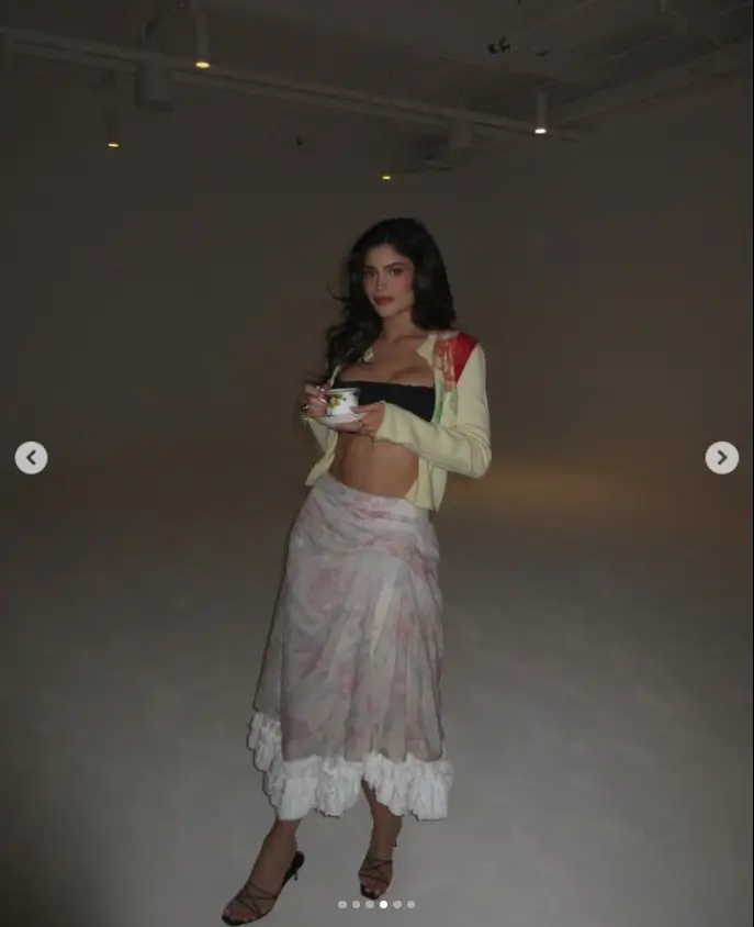 Wearing a black bralette top and a high-waisted, floral-patterned skirt with a lace hem at the bottom, Kylie Jenner revealed her sculpted midriff.