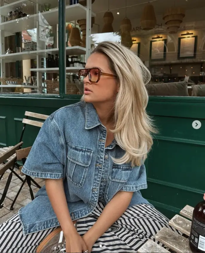 Molly-Mae Hague appeared sensational in an oversized blue denim shirt and orange-tinted shades while grabbing a drink in a cafe on Wednesday.