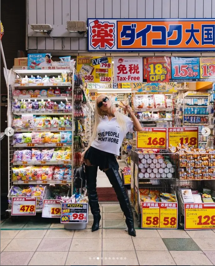 Wearing thigh-high black leather boots and a teeny tiny black miniskirt, Christina Aguilera struts her stuff around Tokyo.