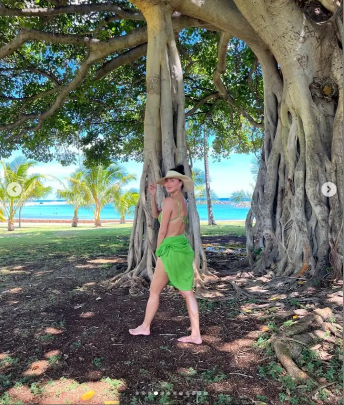 On her trip, she posed for a selfie with her partner wearing a neon green bikini and a large sunhat while she looked fantastic.