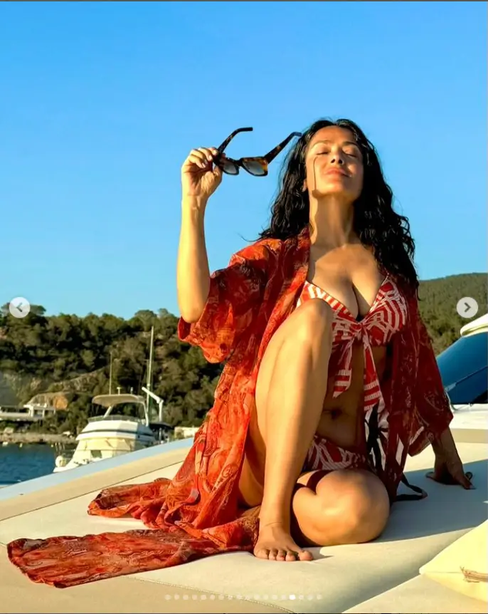 With one hand on a surface by her head, Salma posed from a speedboat while wearing an itty-bitty, multicolor swimsuit, retaining her signature class as she plunged for an eye-popping view.