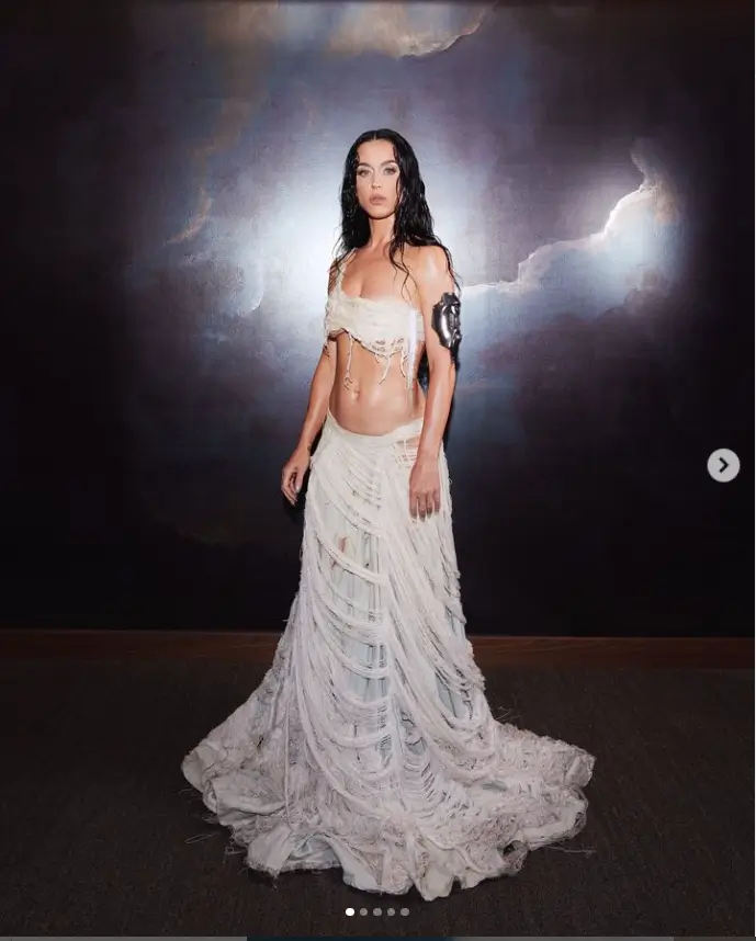 Katy Perry wore a distressed two-piece gown revealing her cleavage while hiding her toned legs under a low-waisted floor-length skirt.