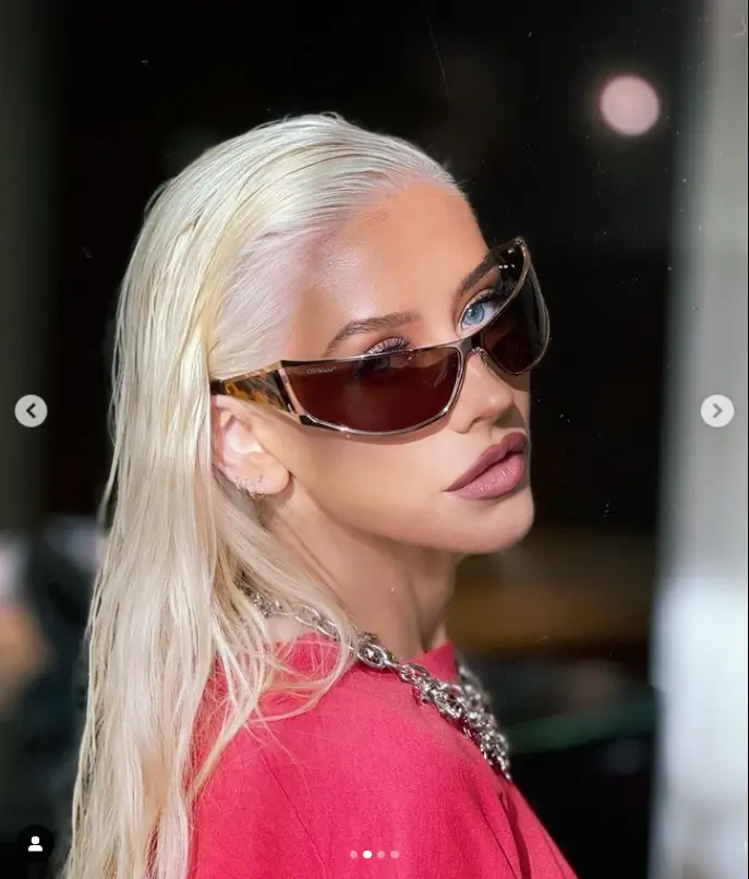 A second picture shows her sporting Off-White sunglasses and a variety of hoop earrings while showering off her blue orbs.