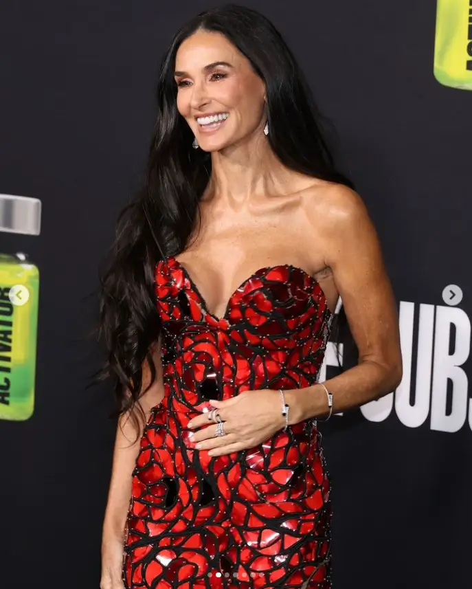 In a figure-hugging, strapless black-and-red dress, Demi Moore looks years younger than her age at the LA premiere of The Substance