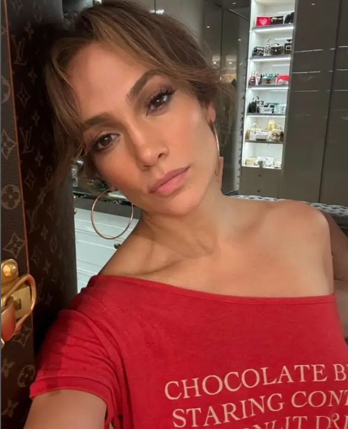 Earlier this week, Jennifer Lopez took to Instagram to share a seductive selfie. She wore a red one-shoulder T-shirt featuring chocolate text in white type.