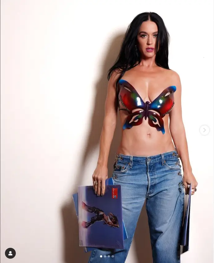 Her toned tummy showed through as she held up her vinyl record beneath an eye-catching breastplate in which she wore baggy low-rise jeans and little else.