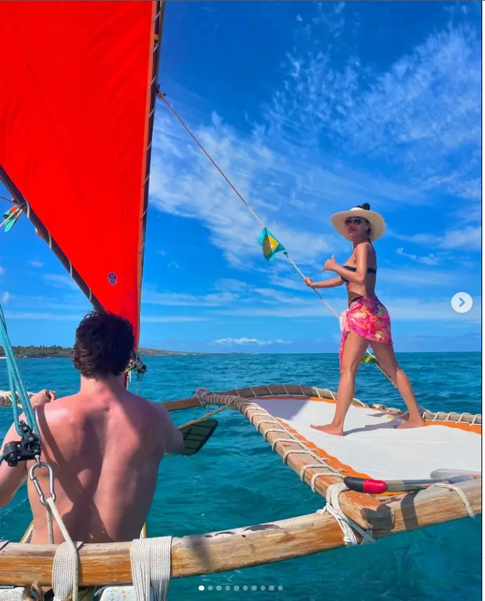 Wearing a pink sarong and sunhat, she gave Thom a thumbs up so he could handle the sails.