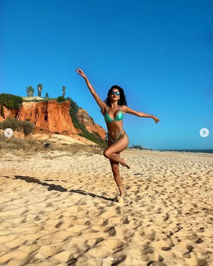 She has been enjoying the sunshine with her fiancé Thom Evans after heading to the beach, sporting a plunging green string bikini.