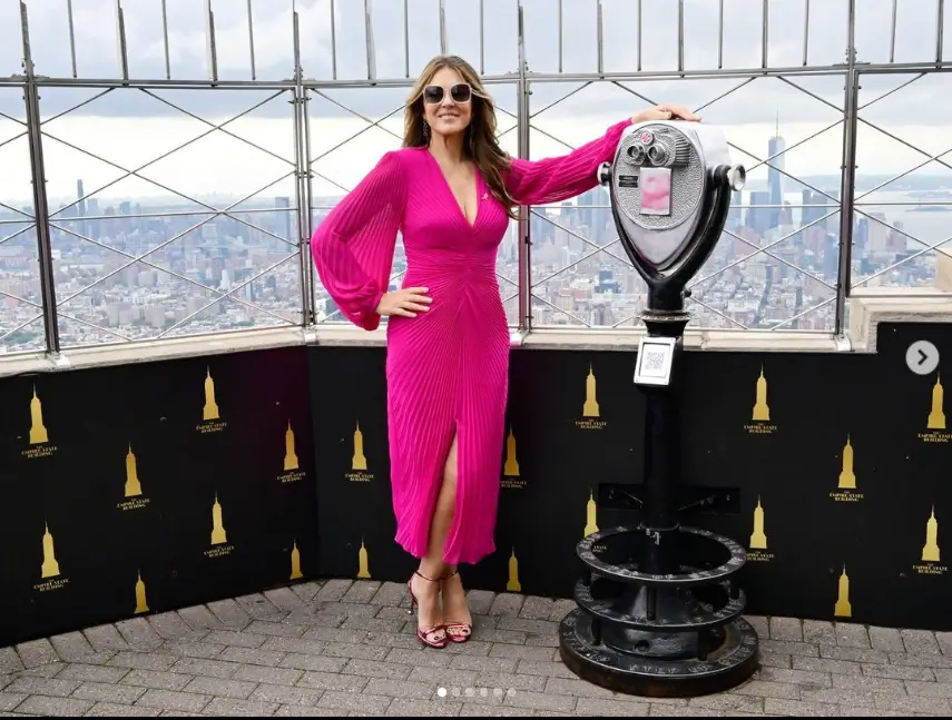 A bright pink pleated dress envelops Elizabeth Hurley's figure and features draping arms as she took to the streets of New York 