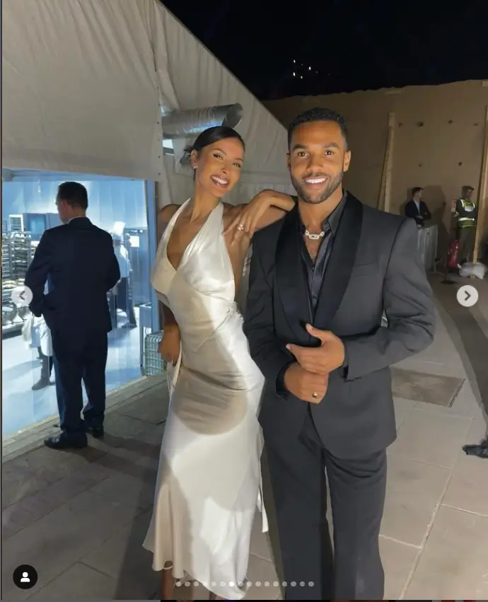 In high spirits, she posed with Lucien Laviscount. The actor wore black trousers, a black shirt and matching suit jacket.