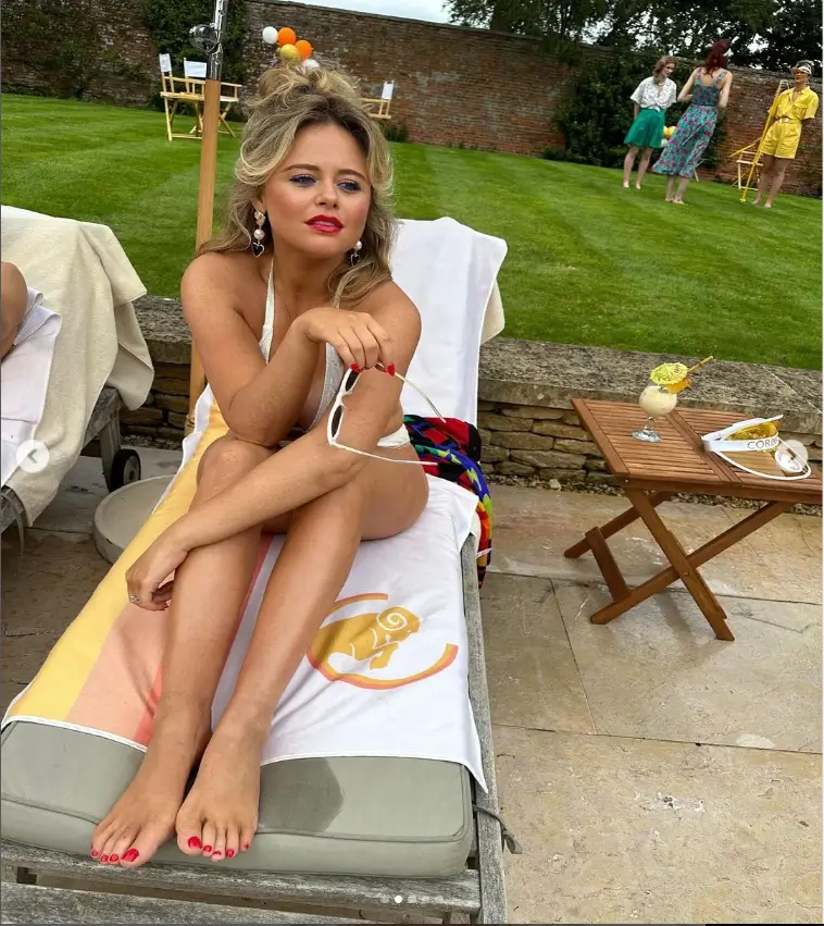 In a series of sizzling behind-the-scenes photos, Emily Atack revealed her famous curves, nearly spilling out of her tiny white bikini