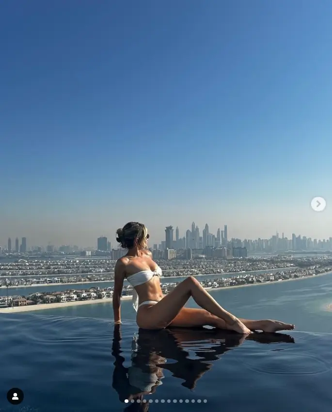 As she gazed at Dubai's stunning skyline in an infinity pool, she wore a strapless white bikini that displayed her toned figure and slender pins.