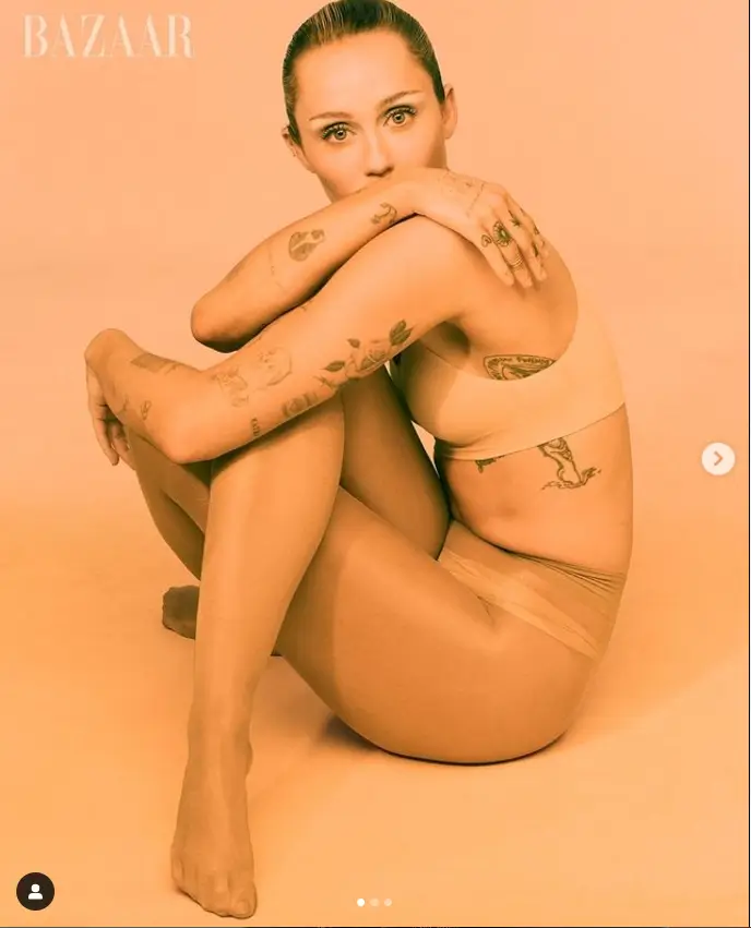 With a direct gaze at the camera, Miley effortlessly flaunts her toned figure in a flexible seated pose on the floor. Her confidence shines through as she effortlessly poses for the camera.