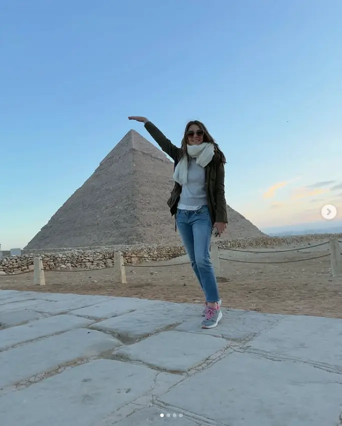 For the outing, Elizabeth opted for a cozy and chic look with a grey sweater and jeans paired with a brown coat, stylish shades, and a scarf to keep her warm in the desert's early morning chill.