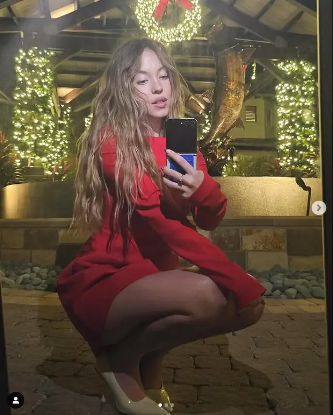 Get ready for the holiday season with a stunning ruby-red mini dress worn by Sydney Sweeney in her recent photos. This festive dress is perfect not only for Christmas Day gatherings, but also for any special occasion.