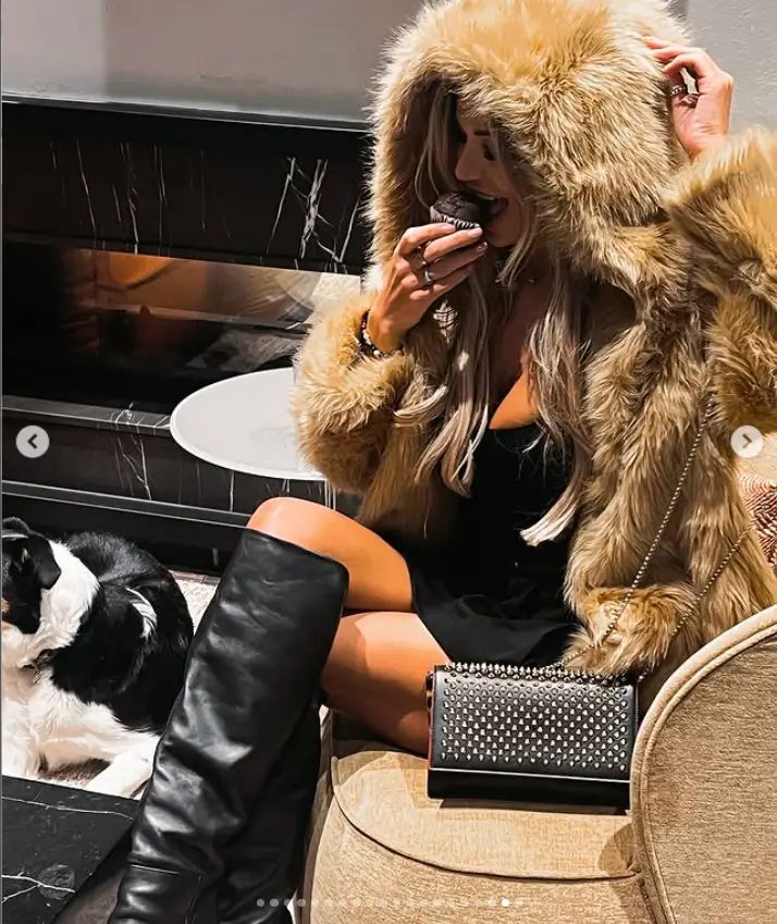 Christine looked stunning in her faux fur hooded coat and leather knee-high boots, striking up a pose for the camera.