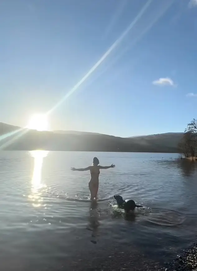 As she walks into the water, the woman is soon joined by her trusty black Labrador Mona who quickly swims out to her side. Together, they enjoy the calming waters and create a beautiful bond between human and furry companion.