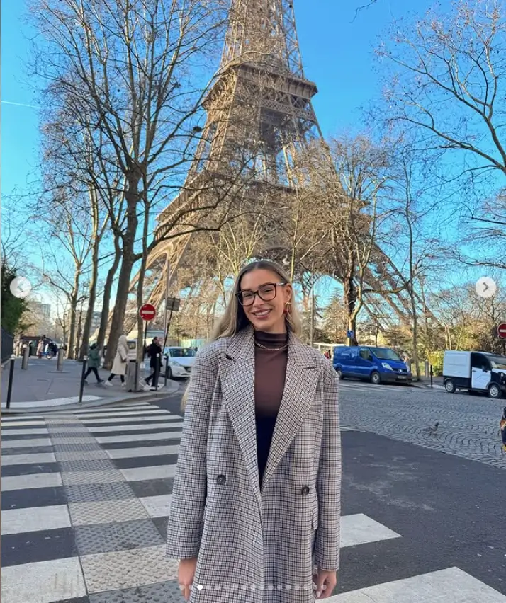 Zara looked effortlessly fashionable in Paris as she posed with a smile in front of the iconic Eiffel Tower. Her outfit, consisting of a brown top and a houndstooth trench coat, perfectly captured the city's chic aesthetic.