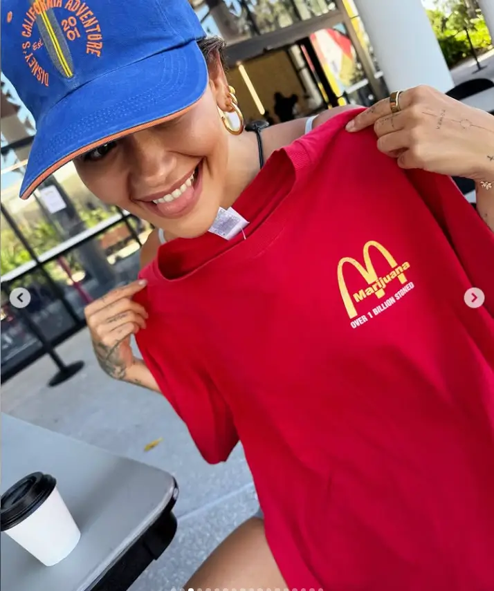 One of the images showed Rita proudly displaying a red t-shirt with the iconic McDonald's logo, playfully sticking her tongue out for the camera.