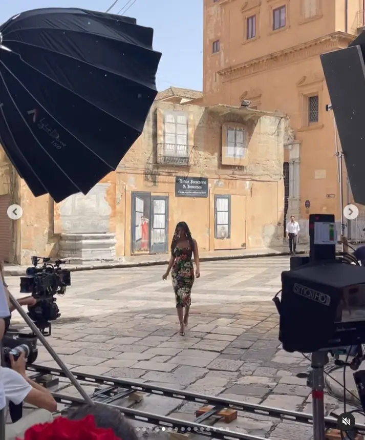 The cameras closely followed her every move as she confidently walked through the beautiful town square, with the sun shining down upon her. She shared this lovely video from the set, giving a glimpse into this picturesque location.